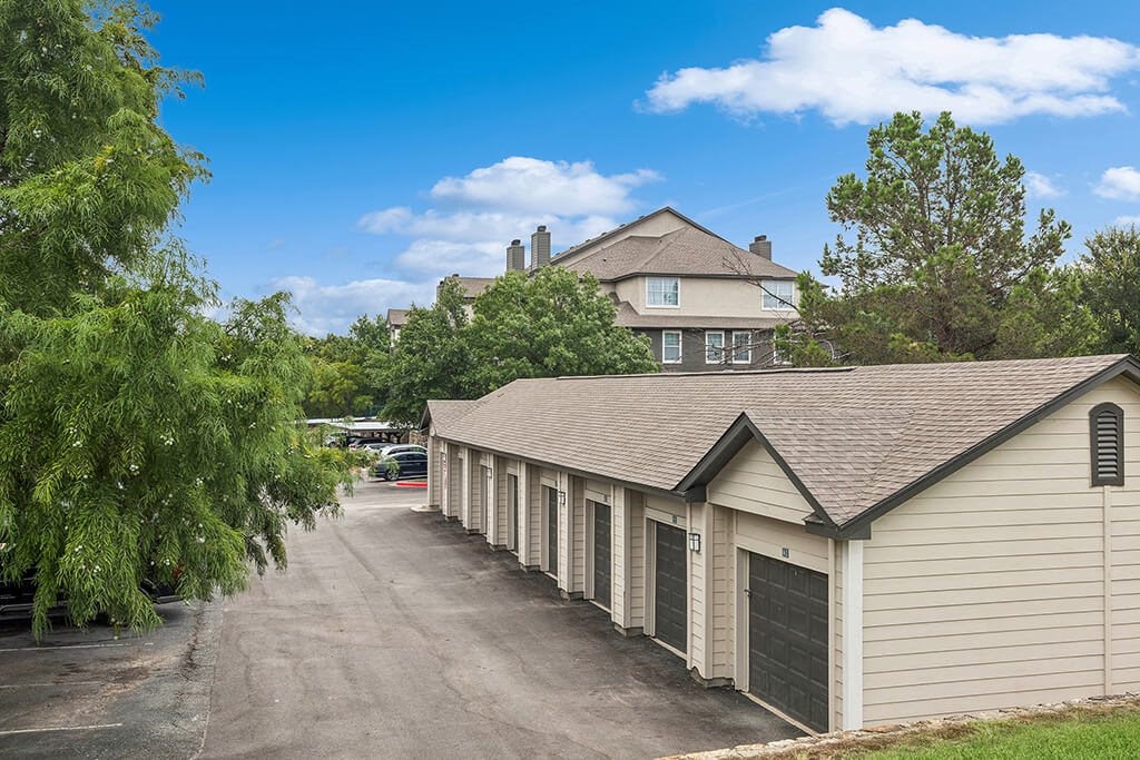 A row of garages are in front of a house.